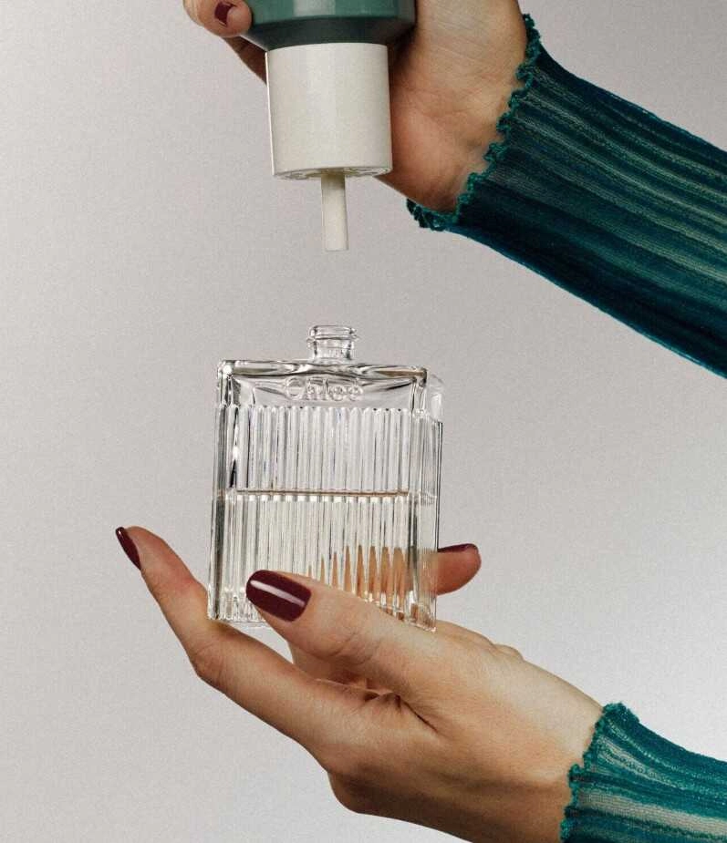 Douglas-sieviete pārlej smaržas pudelītē